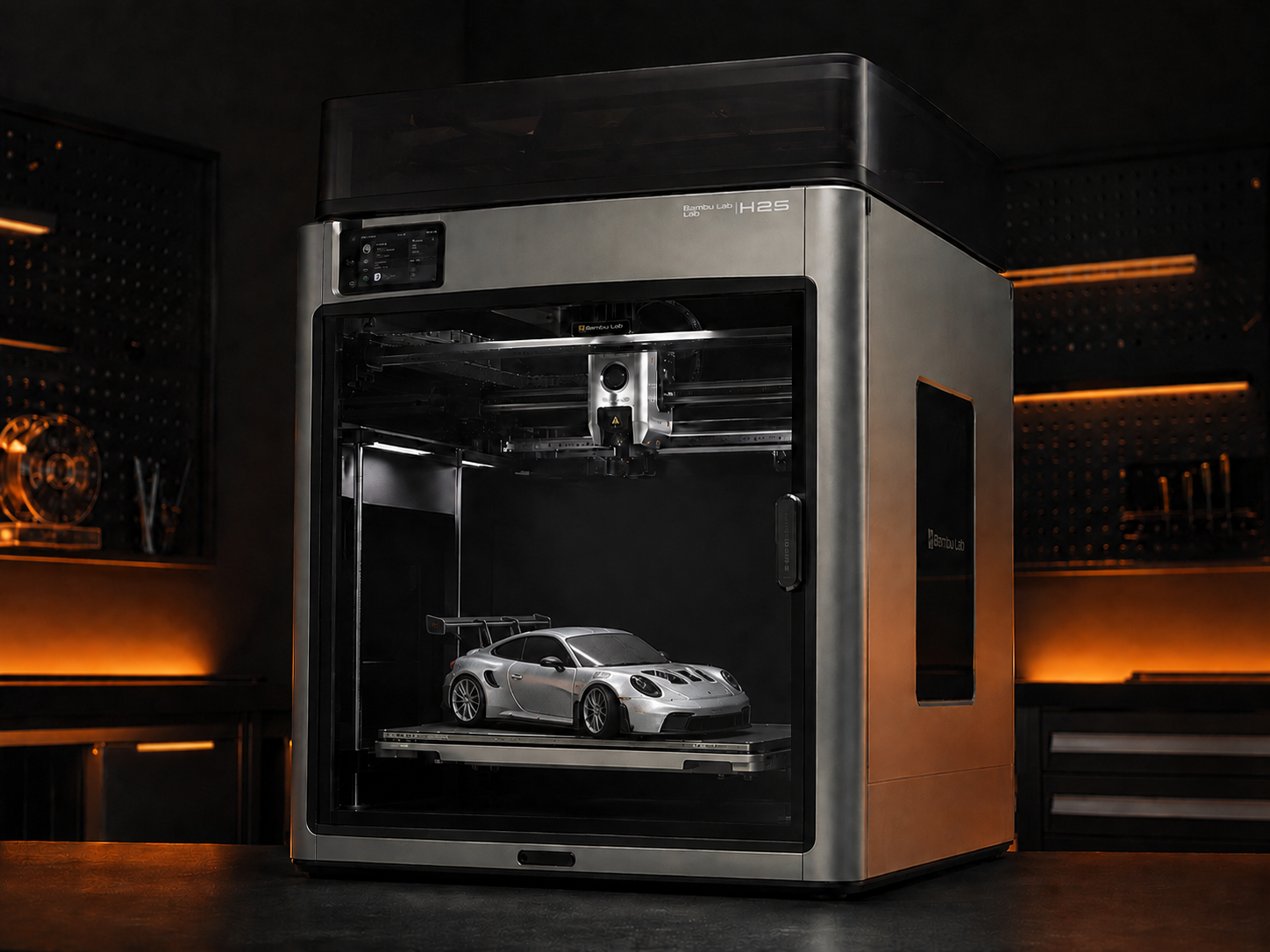 Silver 3D-printed sports car inside an enclosed professional 3D printer